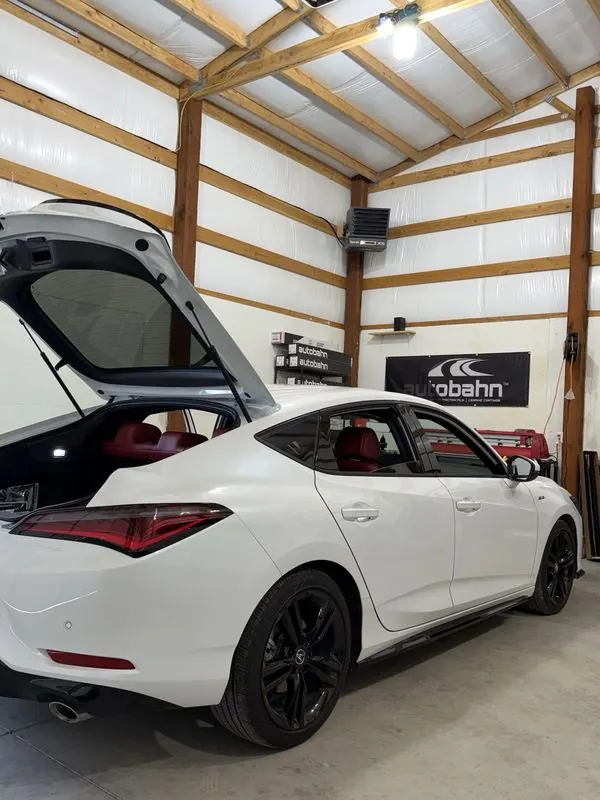 White Acura Integra with tinted windows and the hatch open